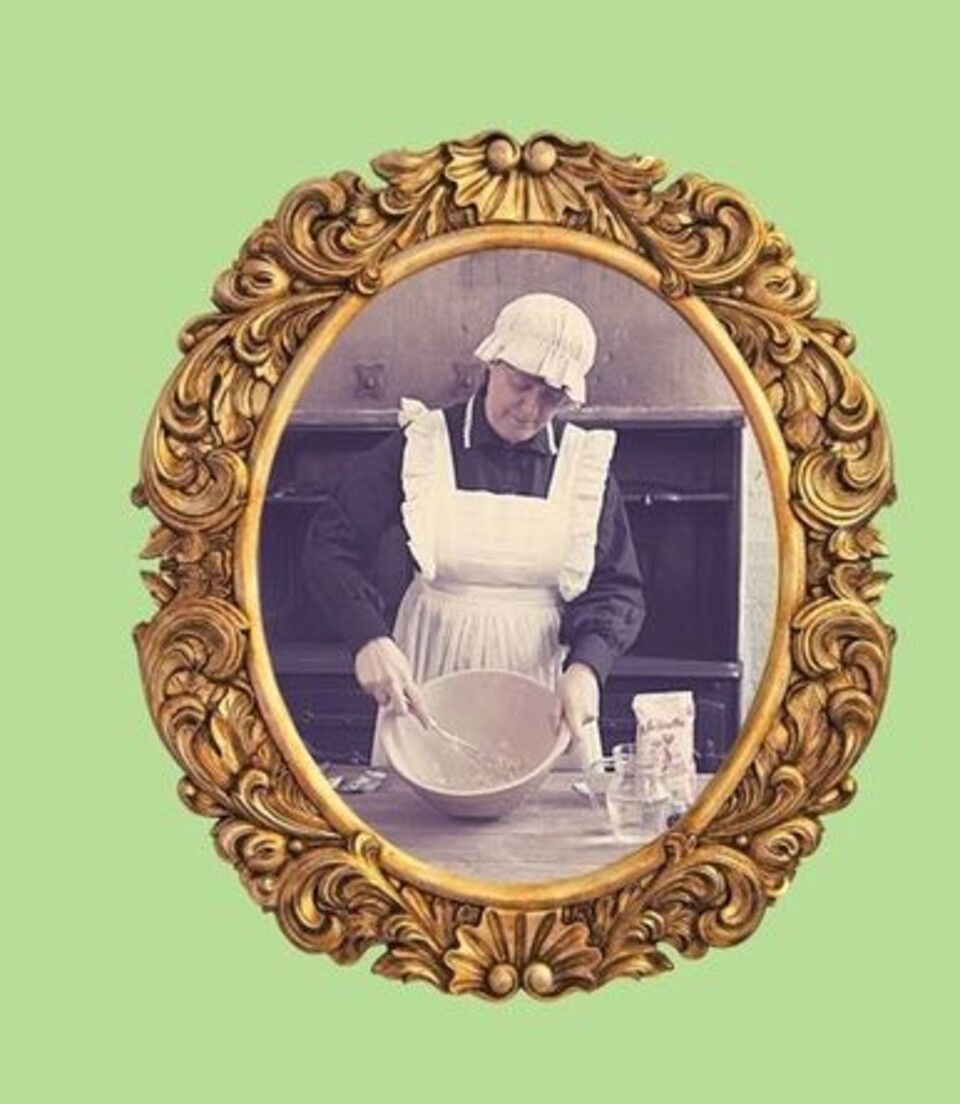 Sepia photo of a woman mixing something in a bowl, dressed in Victorian maids costume